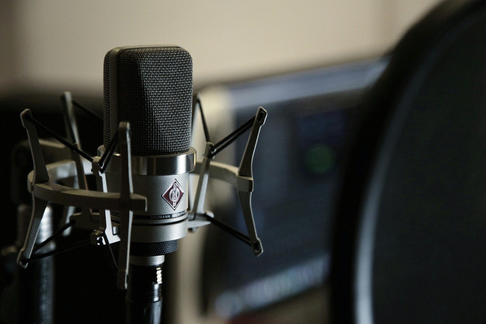 Detailed view of a condenser microphone in a recording studio setting.